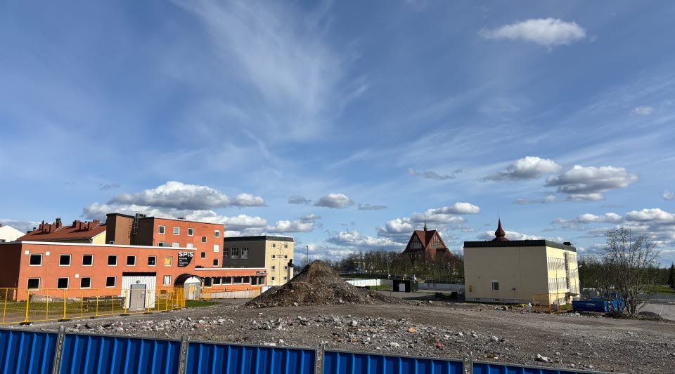Fotot visar hus som avvecklas bakom stängsel.