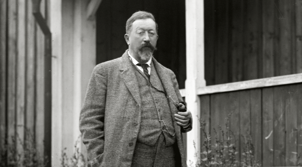 Svartvitt fotografi av Hjalmar Lundbohm stående utanför sin disponentvilla. 