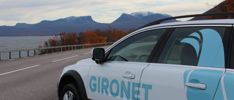 I förgrunden syns delar av en bil med dekalen Gironet och Kiruna kommuns grafiska ripa. I bakgrunden syns Lapporten.