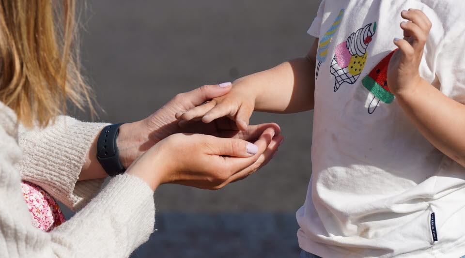 Bild på en vuxen och ett barns händer