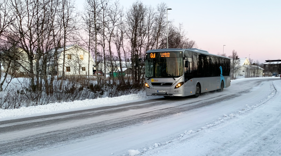 En lokaltrafikbuss kör längs en gata på vintern