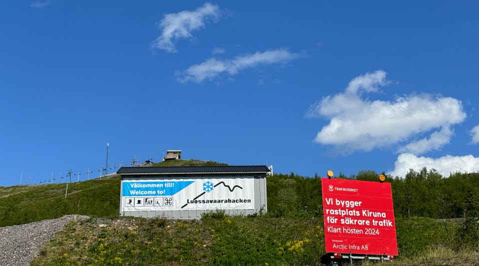 fotot visar skyltar med information och en slalombacke mot en blå himmel.