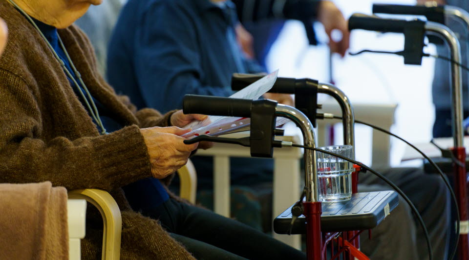 En äldre person som sitter med sin rullator