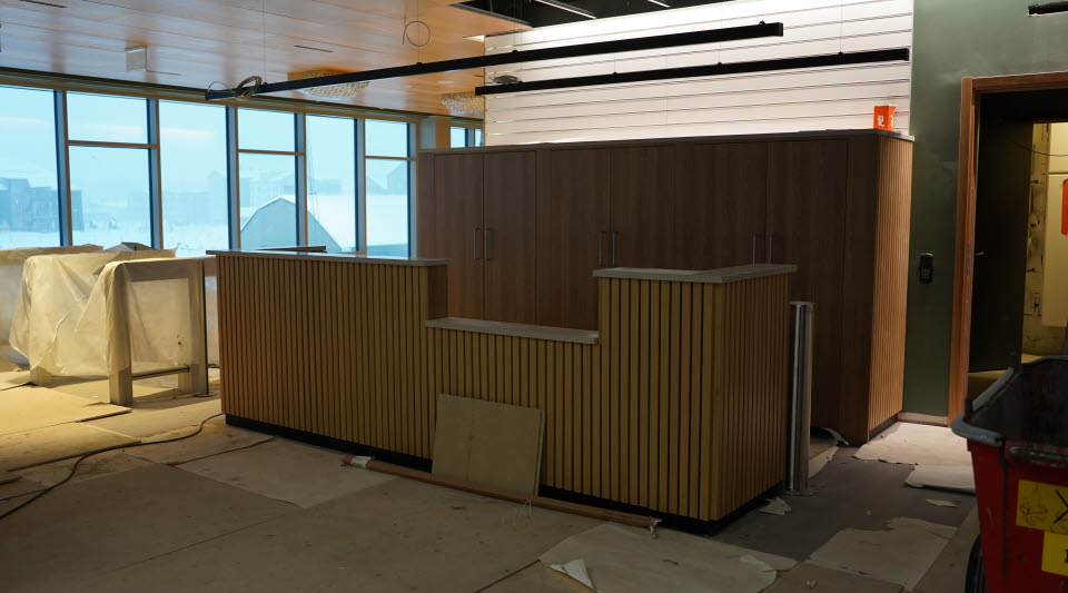 Fotot visar en reception med fönster bakom i ett rum under uppbyggnad.