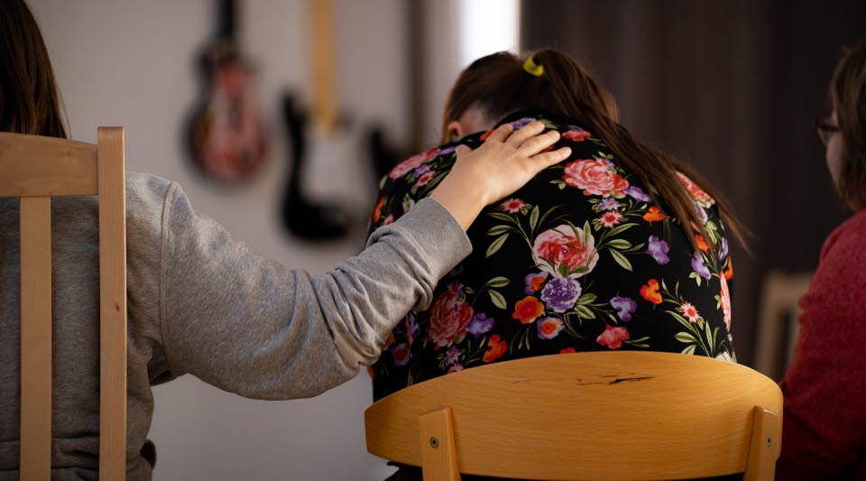 Två personer bakifrån där ena håller armen på den andras axel