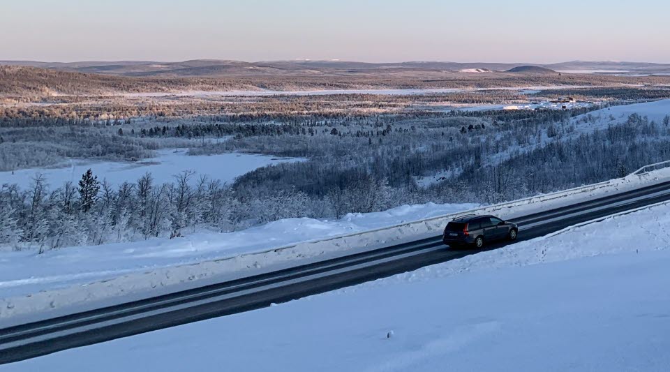 Fotot visar en väg med en hög bro vintertid.