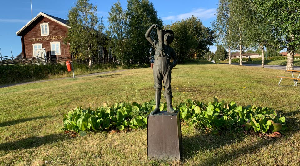 Skulptur i Svappavaara. Hembygdsgården i bakgrunden. 