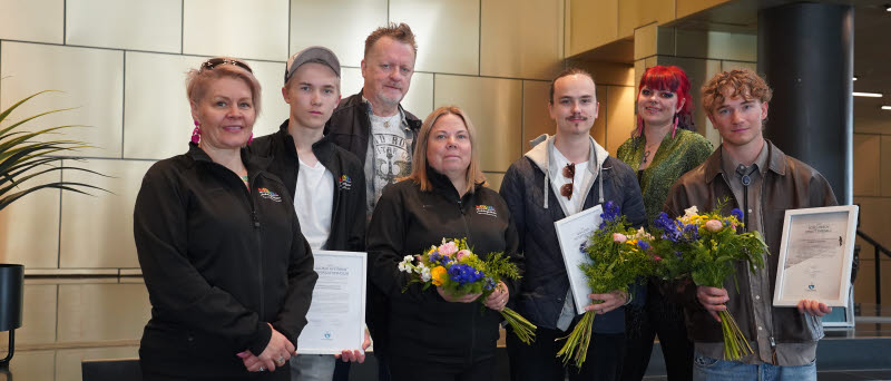 Stipendiater och representanter från Kiruna kommun poserar med blommor och diplom i stadshushallen