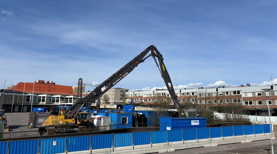 Fotot visar hus som avvecklas bakom stängsel.