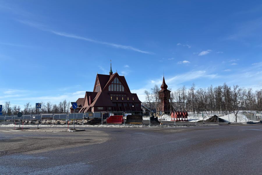 Fotot visar en kyrka bakom byggstängsel med en blå himmel bakom. 