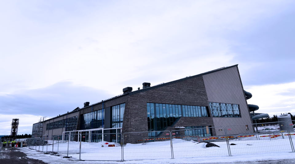 Fotot visar en bassäng ett badhus med rutschkanor under uppbyggnad.