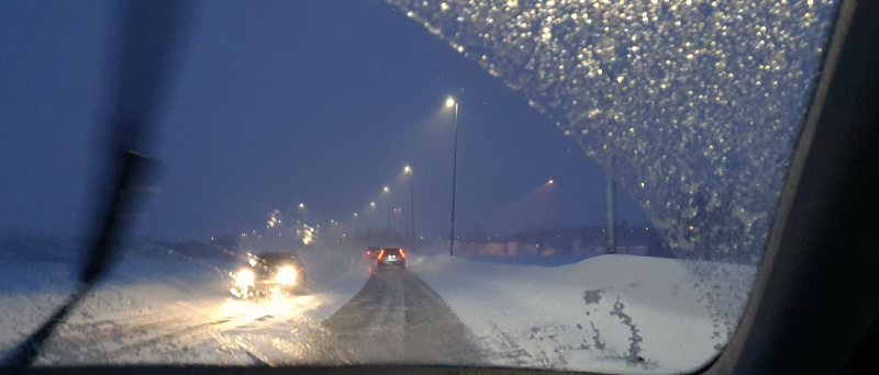 Utsikt genom en bils vindruta under snöoväder