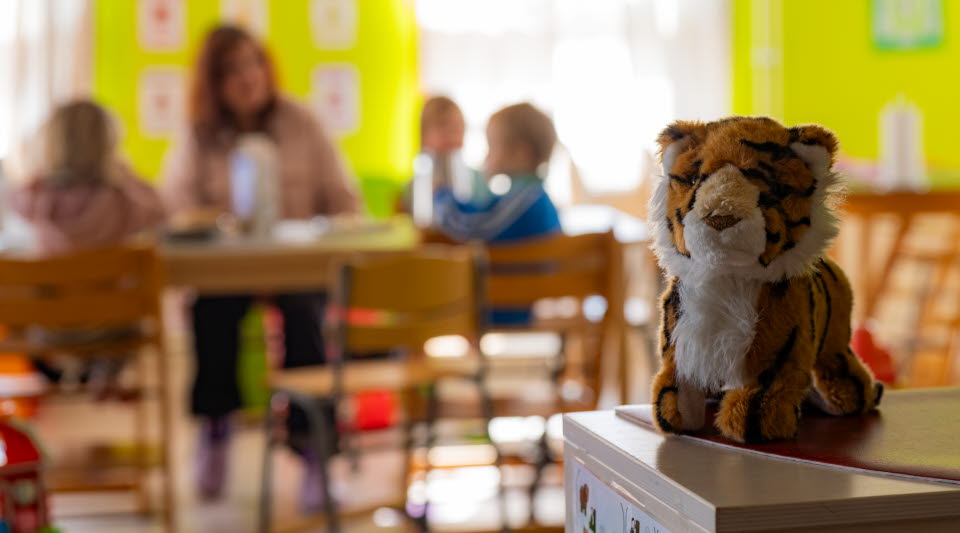 Tigernalle som sitter i ett rum med barn och pedagoger.