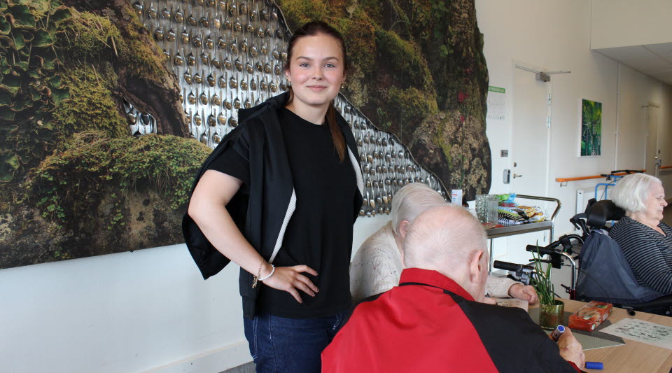 ung kvinna på ett äldreboende tittar in i kameran och ler