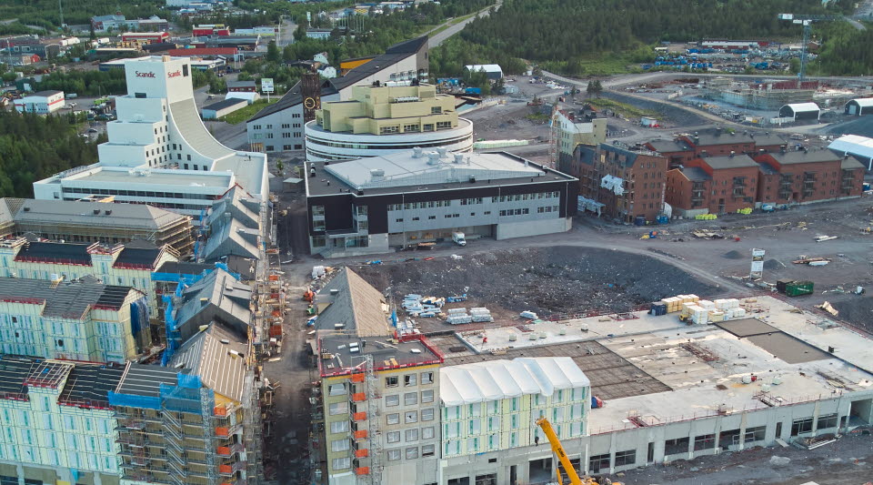 Den bruna och grå byggnaden Aurora kultur & kongress står närmast Kristallen, stadshus och länskonstmuseum, som är en snövit byggnad..