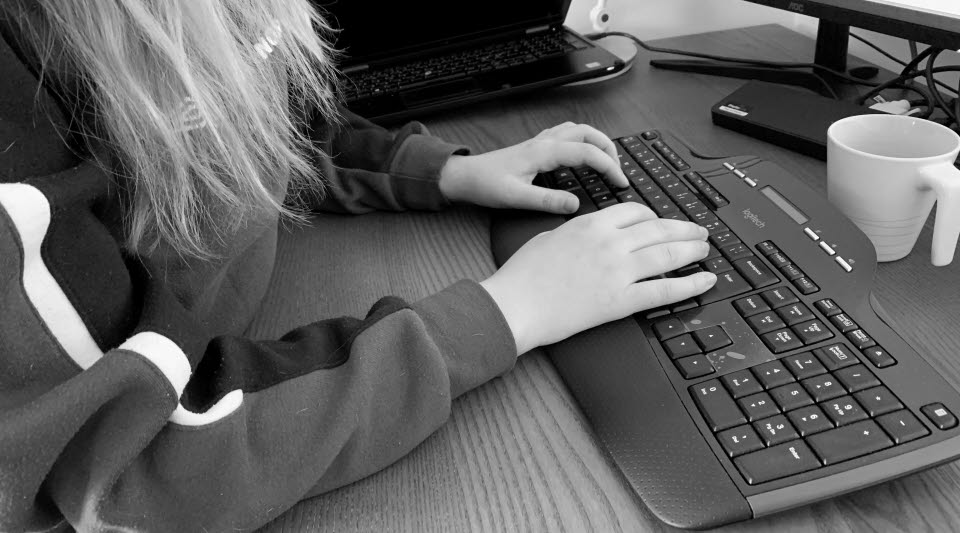 En person sitter med händerna på ett tangentbord