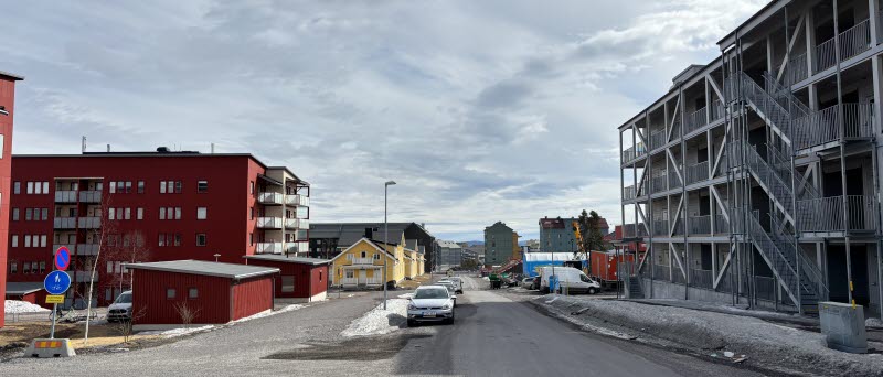 Fotot visar en gata med hus i olika färger och storlekar. 