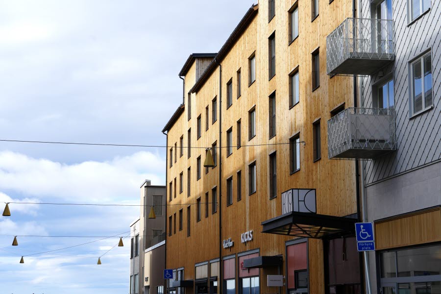 Gatuperspektiv med flera byggnader i Kiruna centrum, där fasader med olika material och uttryck ligger sida vid sida.
