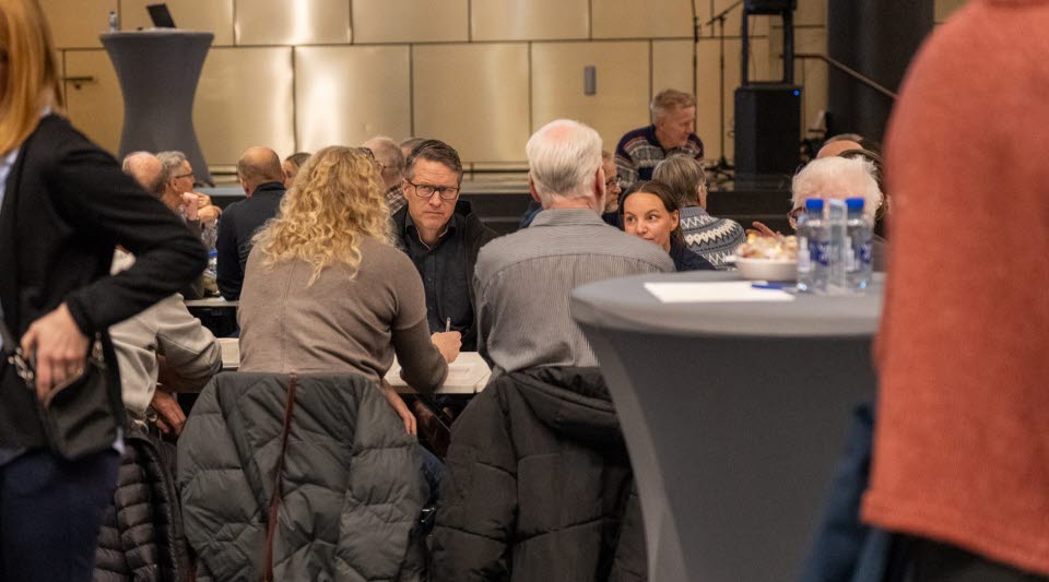 Grupp människor som talar runt ett bord. 