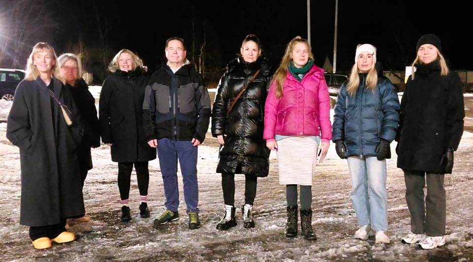 Åtta personer står på rad i vinterkläder och snö under fötterna