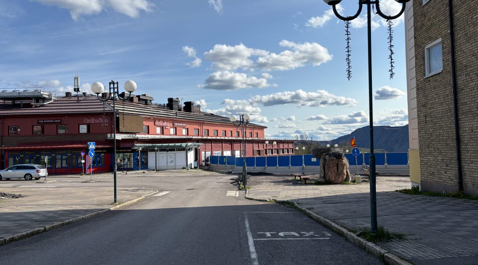 Fotot visar hus som avvecklas bakom stängsel.