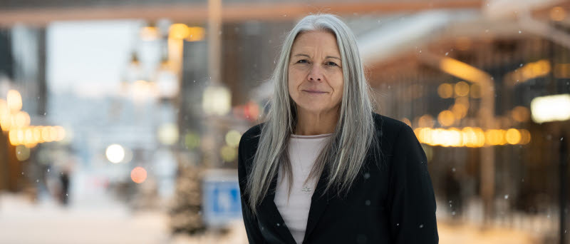 En kvinna i kavaj i utomhusmiljö.