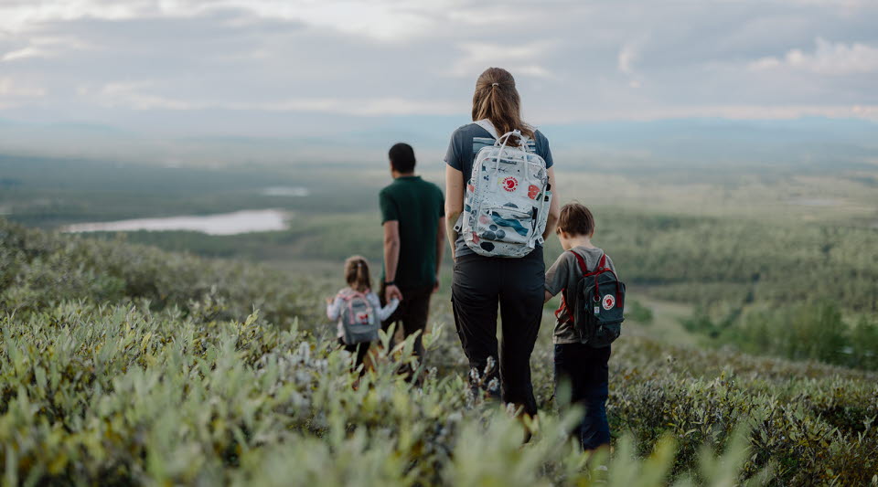 Familj vandrar över ett fjäll. 